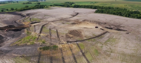 In an aerial view, trenches appear as long dark lines in a field.