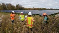 Workers next to solar panels